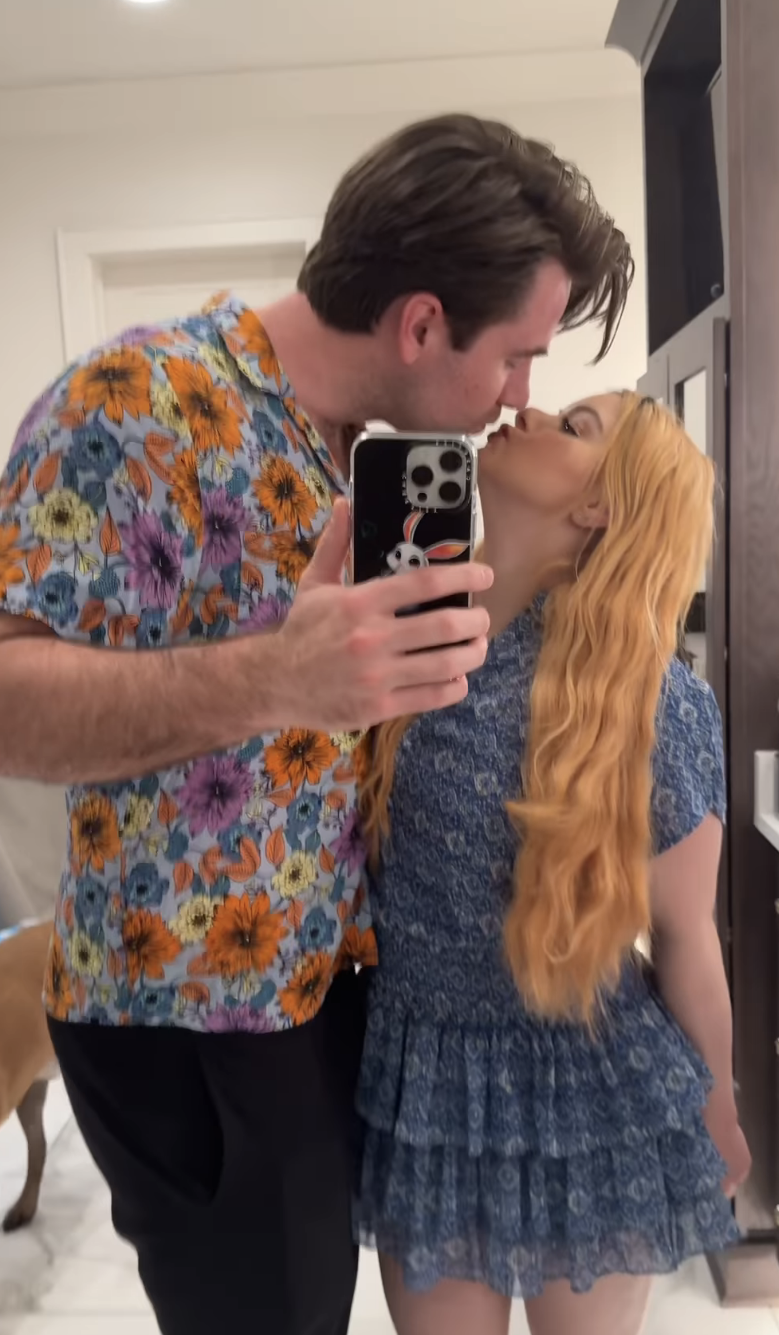 Two individuals embracing, one in a dotted shirt and the other in a blue dress, indoors. There is a text overlay from an Instagram post