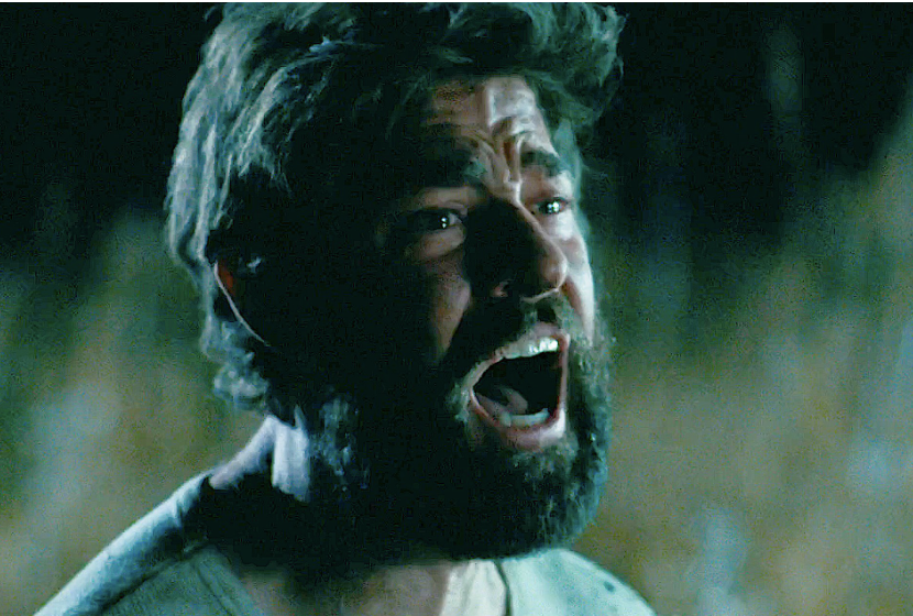 Anguished man with beard and messy hair screaming in distress