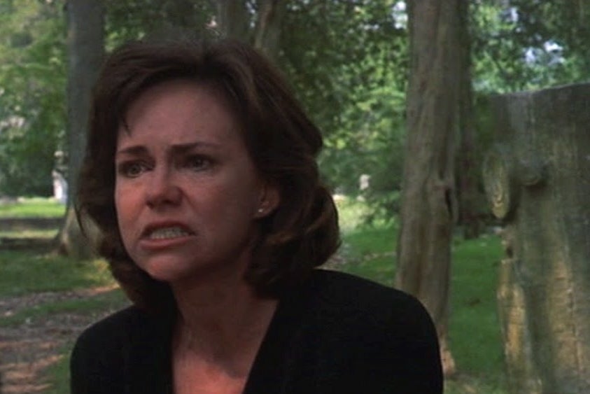 A woman looking distressed in a cemetery from a movie scene