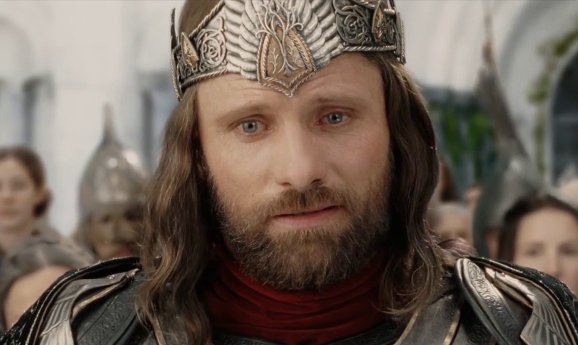 Aragorn in armor with a crown, looking forward with a solemn expression
