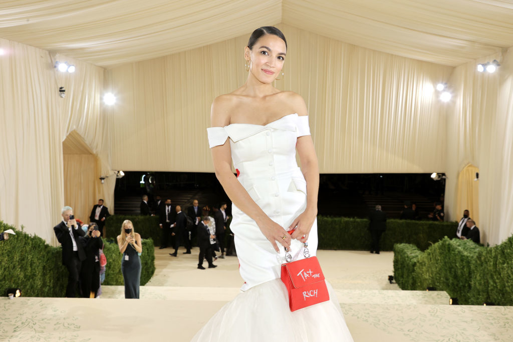 AOC in an off-the-shoulder gown with a small purse at gala