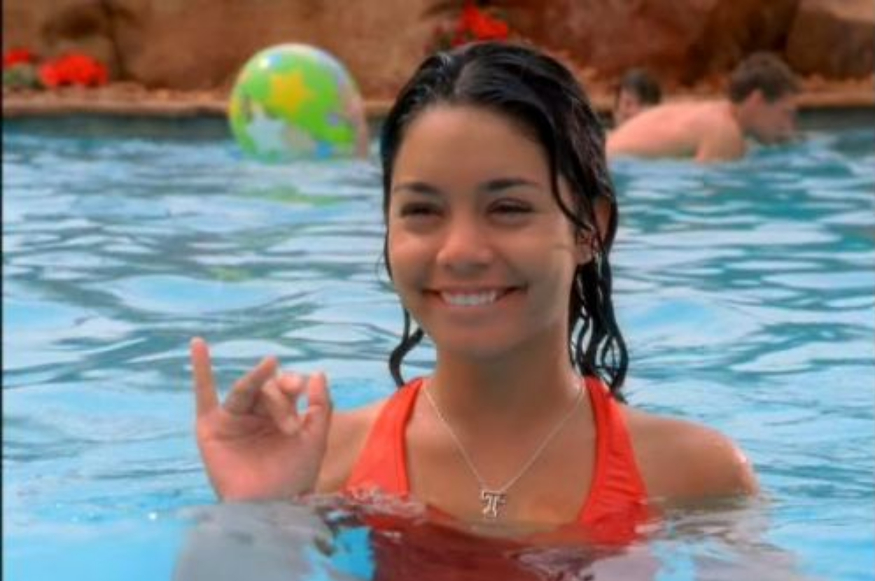 Woman in water making an 'okay' hand sign, smiling at the camera