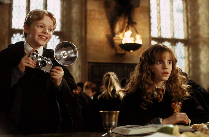 Colin and Hermione Granger in Hogwarts&#x27; Great Hall with a camera