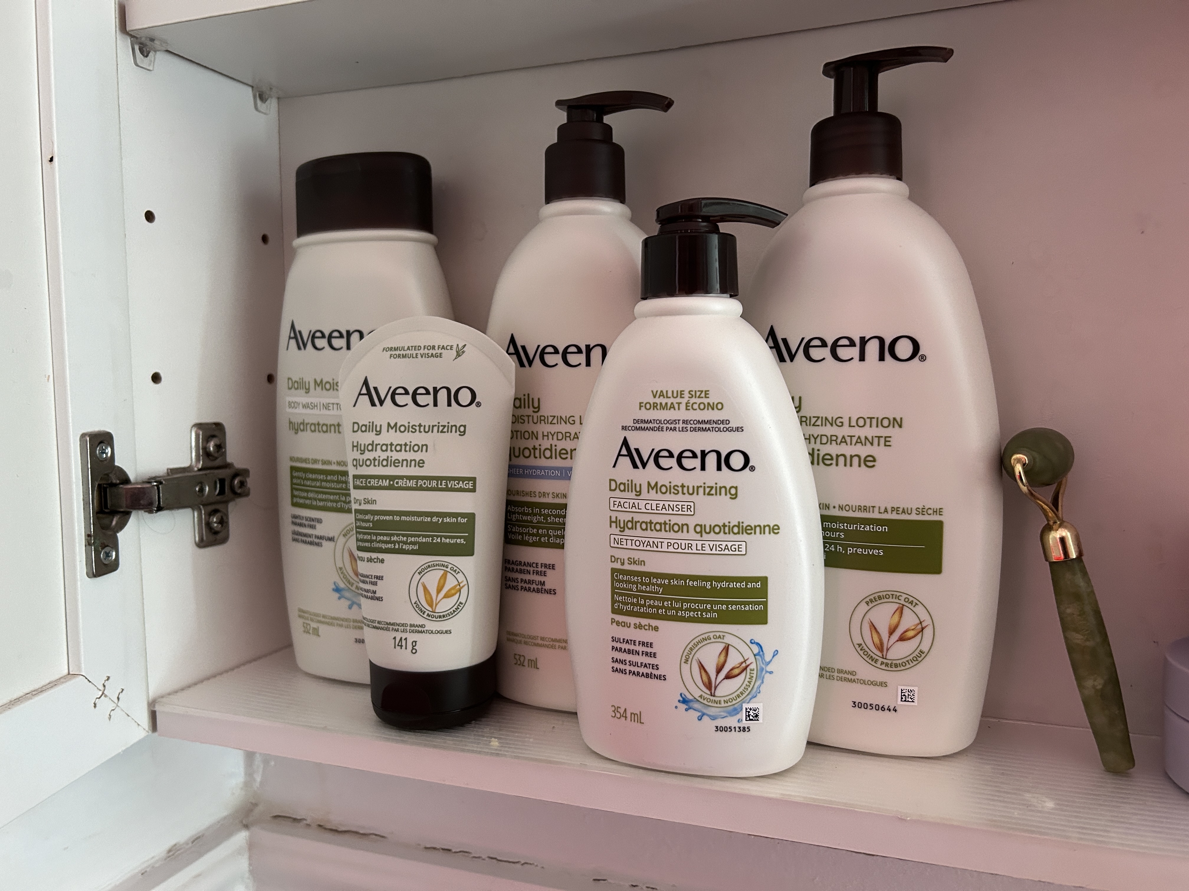 Four bottles of Aveeno lotion on a shelf, emphasizing product variety