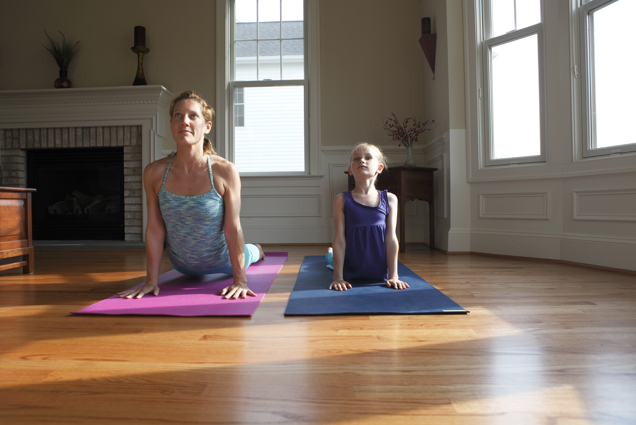 Woman and child practicing yoga together indoors