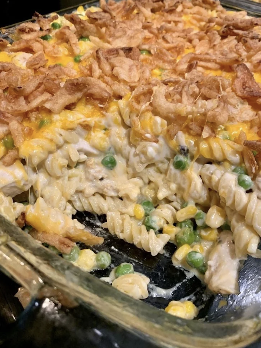 Baked casserole with corn, peas, melted cheese, and crispy onion toppings