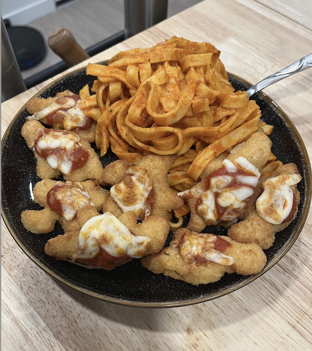 A plate of chicken nuggets with sauce and a side of waffle fries
