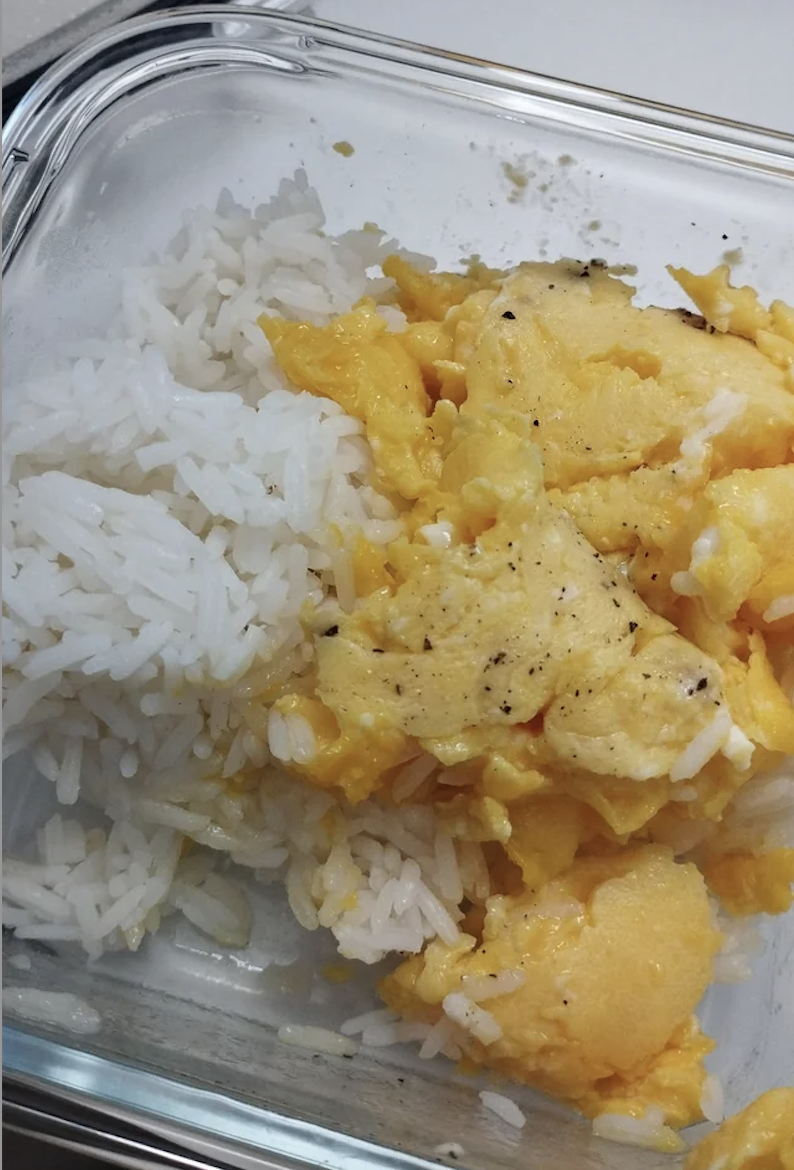 Scrambled eggs and white rice in a glass container