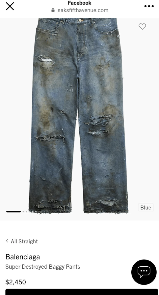 Pair of distressed Balenciaga baggy jeans with rips displayed for sale online, priced at $2,450, indicating high-end fashion