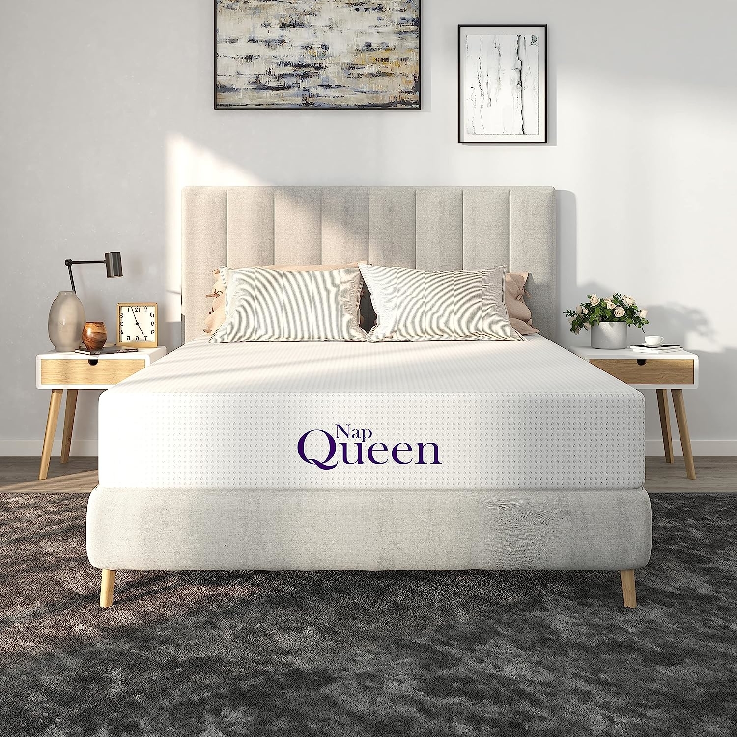 A modern, neatly made bed with &quot;Nap Queen&quot; text on the comfortable-looking mattress in a stylish bedroom setting