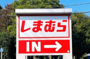 Sign with Japanese characters and "IN" with an arrow pointing right, indicating an entrance