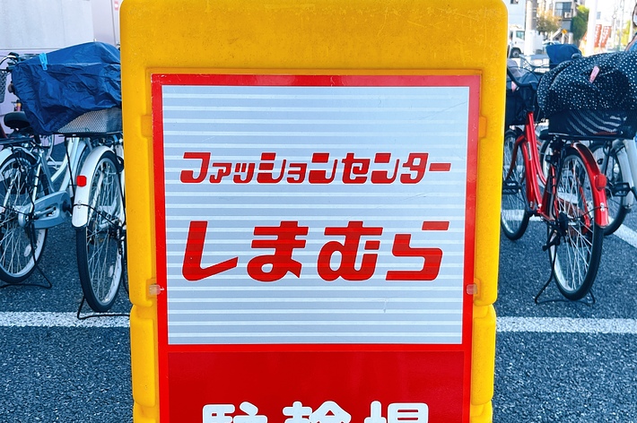 Signboard with Japanese text in front of bicycles; text partially says &ldquo;Furafurashitateru Parking.&quot;