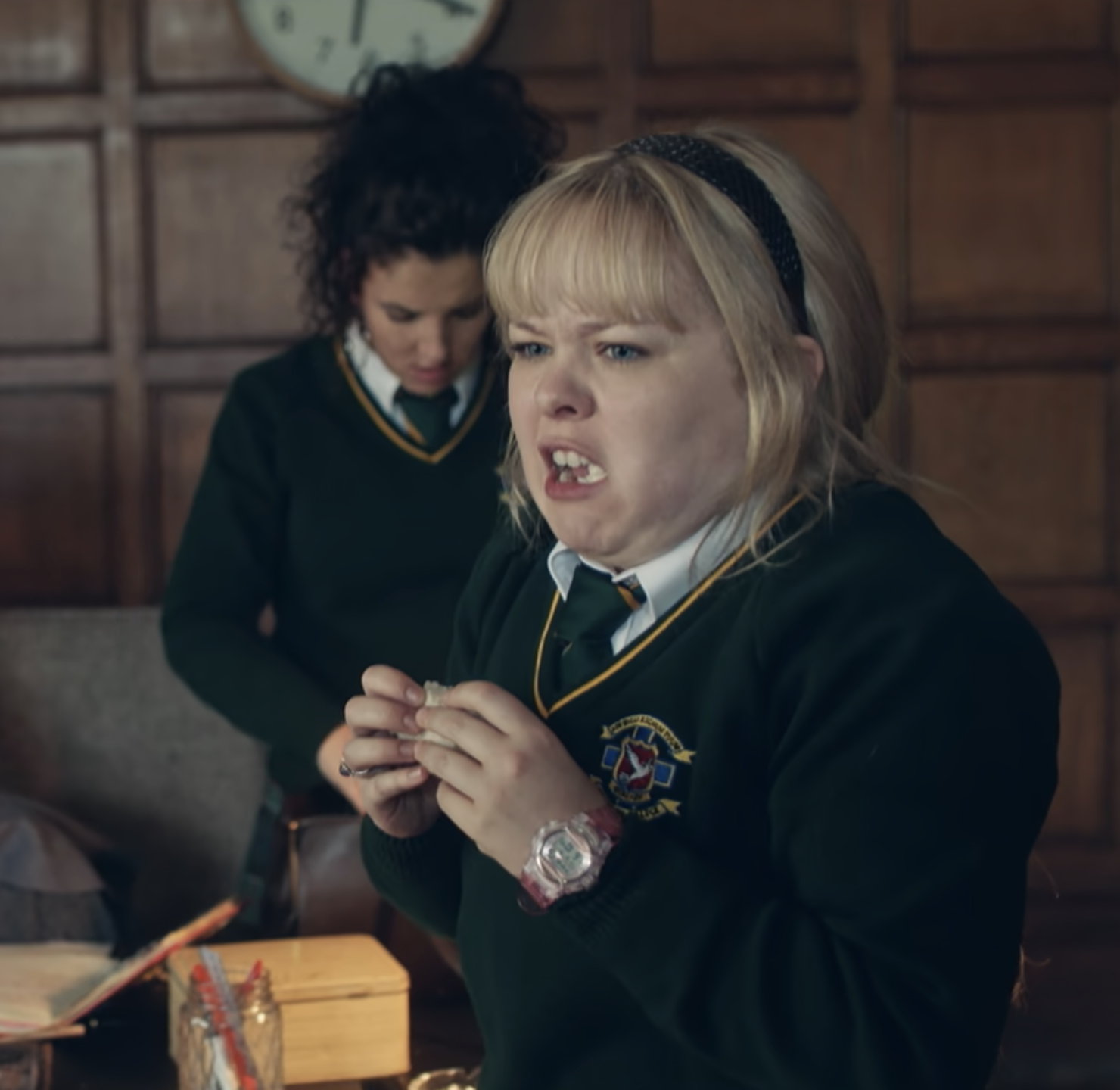 Clare in her school uniform eating a sandwich