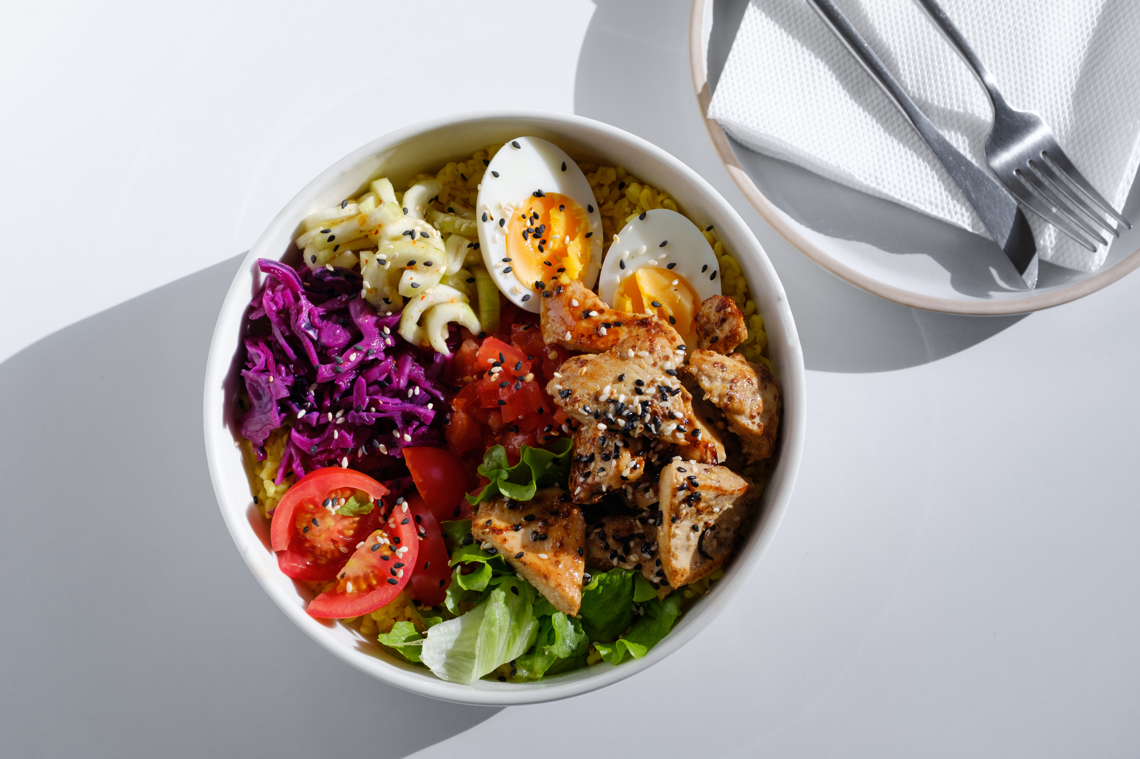 Bowl of healthy mixed salad with various toppings and a hard-boiled egg