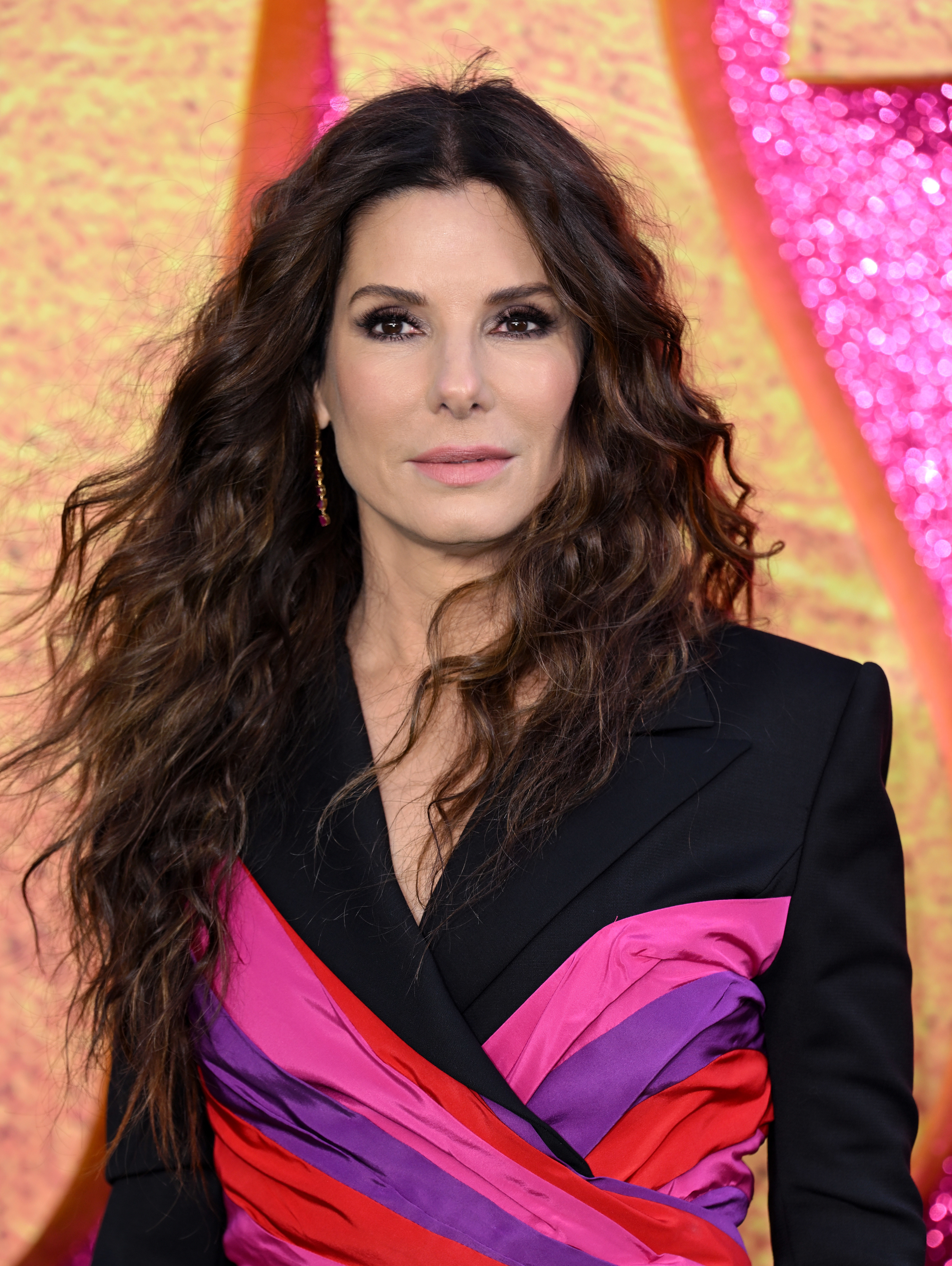 Sandra Bullock wearing a colorful criss-cross dress on the red carpet
