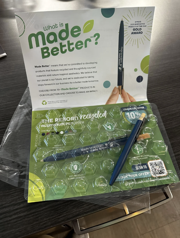 Hand holding a pen with eco-friendly packaging emphasizing sustainable products