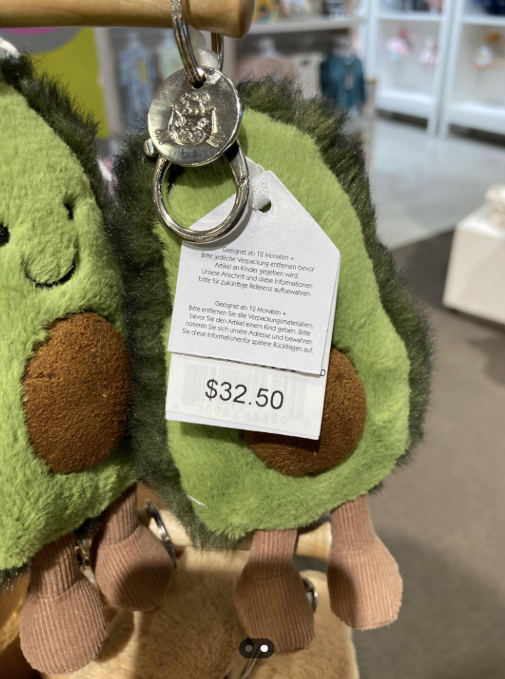 Plush keychain of a green avocado with a price tag displayed, relevant in spending habits content