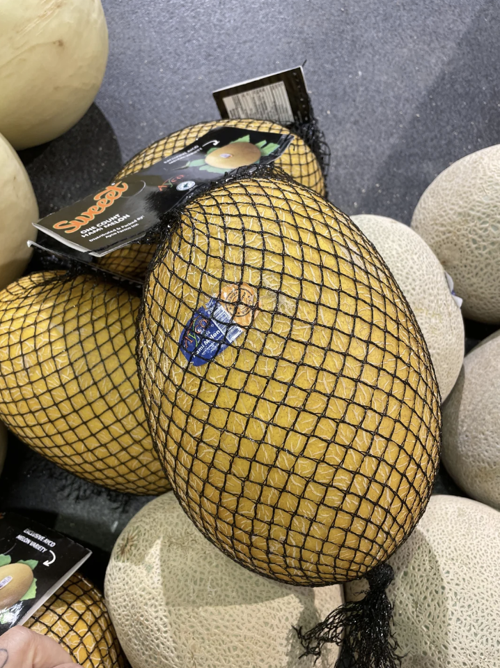 Netted bag of cantaloupes on a market display