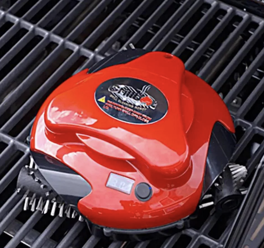 Red robotic vacuum cleaner navigating a metal grill surface