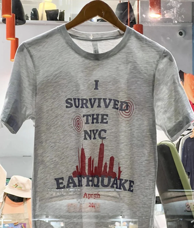 Gray T-shirt with text &quot;I SURVIVED THE NYC EARTHQUAKE&quot; and graphic of city skyline and seismic waves, dated April 1st