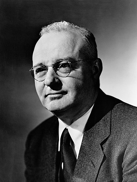Portrait of a man in a vintage suit and glasses looking at the camera