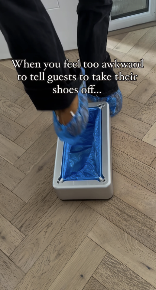 Person using a shoe cover dispenser, implying a solution for guests not removing shoes at home