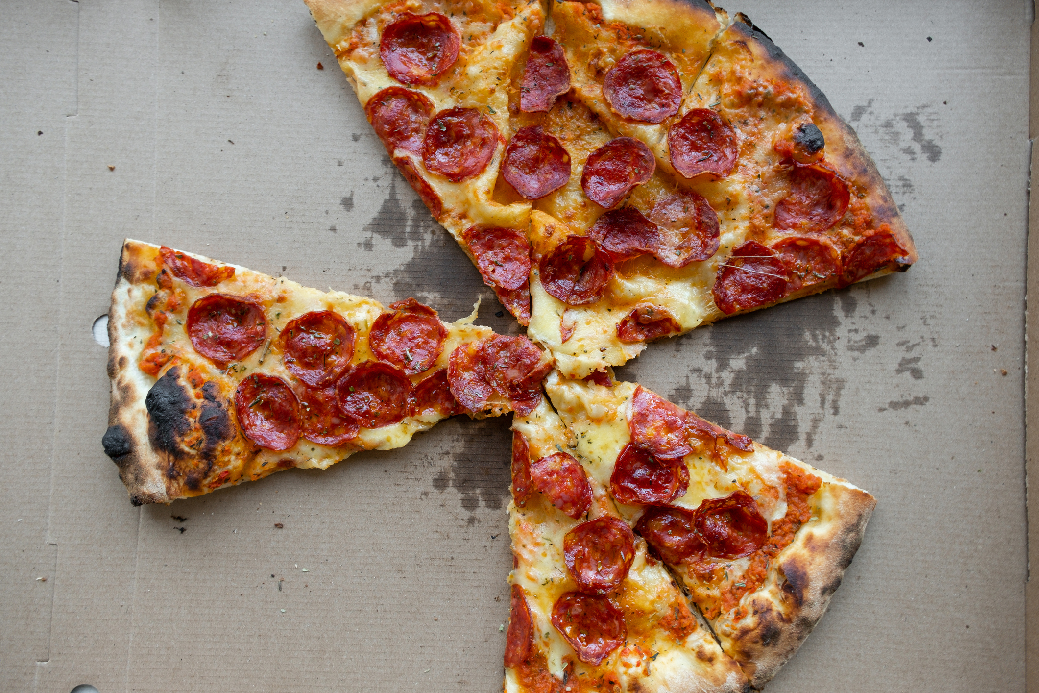 Pepperoni pizza with slices removed, on a cardboard background
