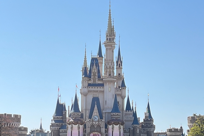 ディズニーランドの城の前に訪れた人々