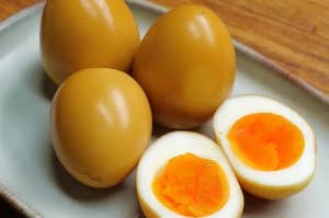半熟の煮卵が皿に3つと、真ん中に切れた煮卵が1つあります。