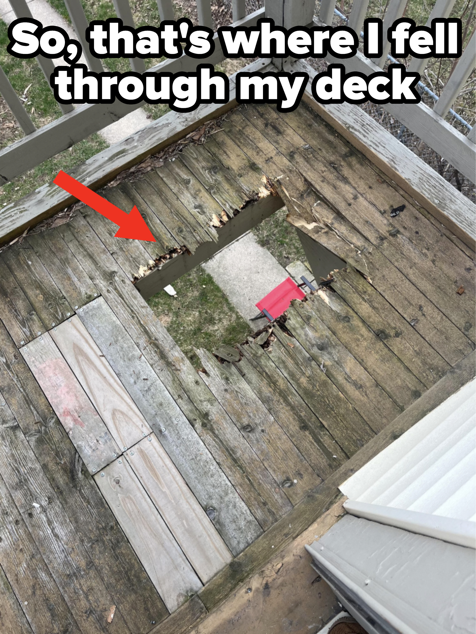 A damaged wooden deck with a sizable hole and a red chair visible below through the opening