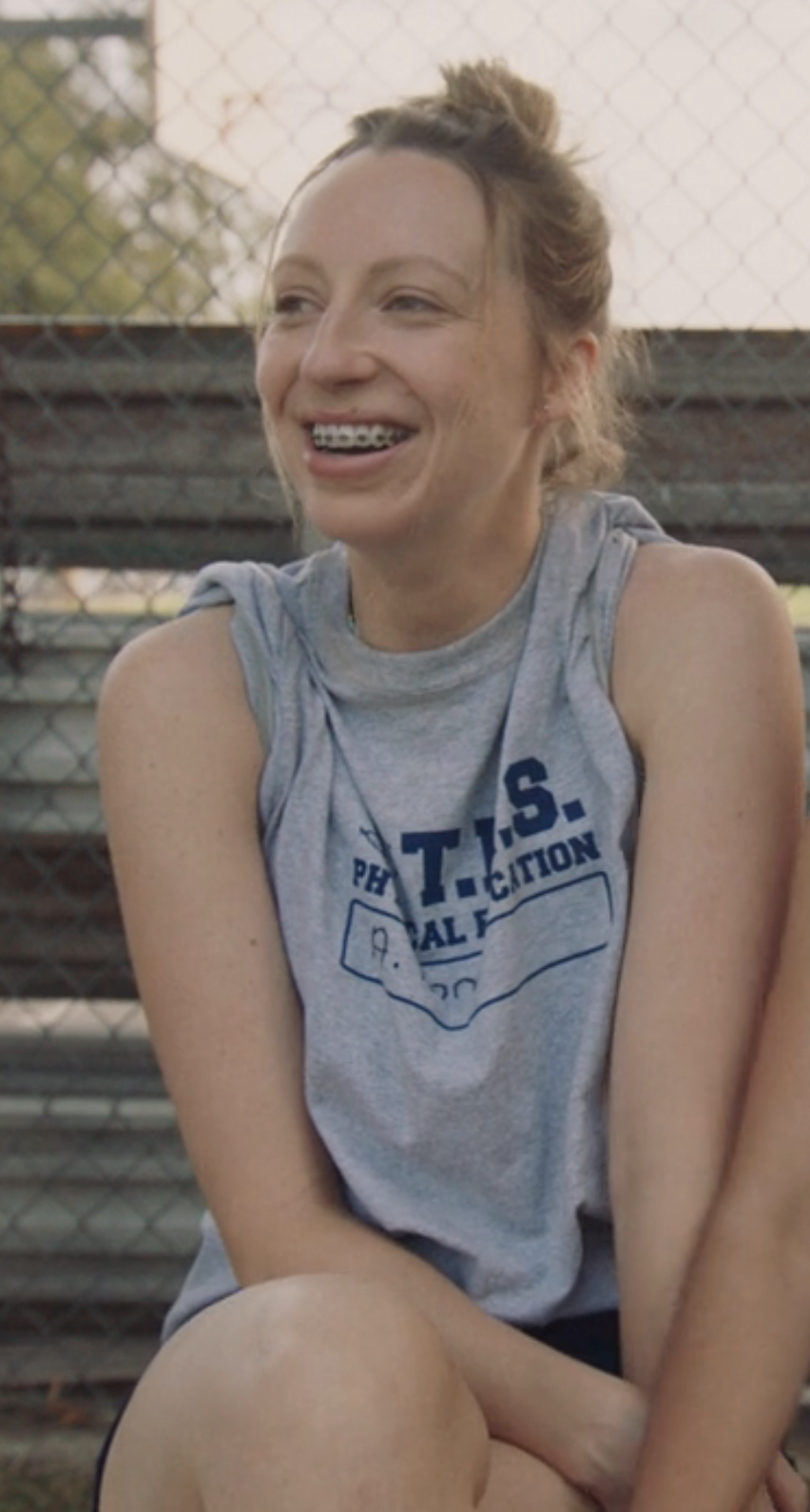 Anna in athletic wear with braces and messy bun