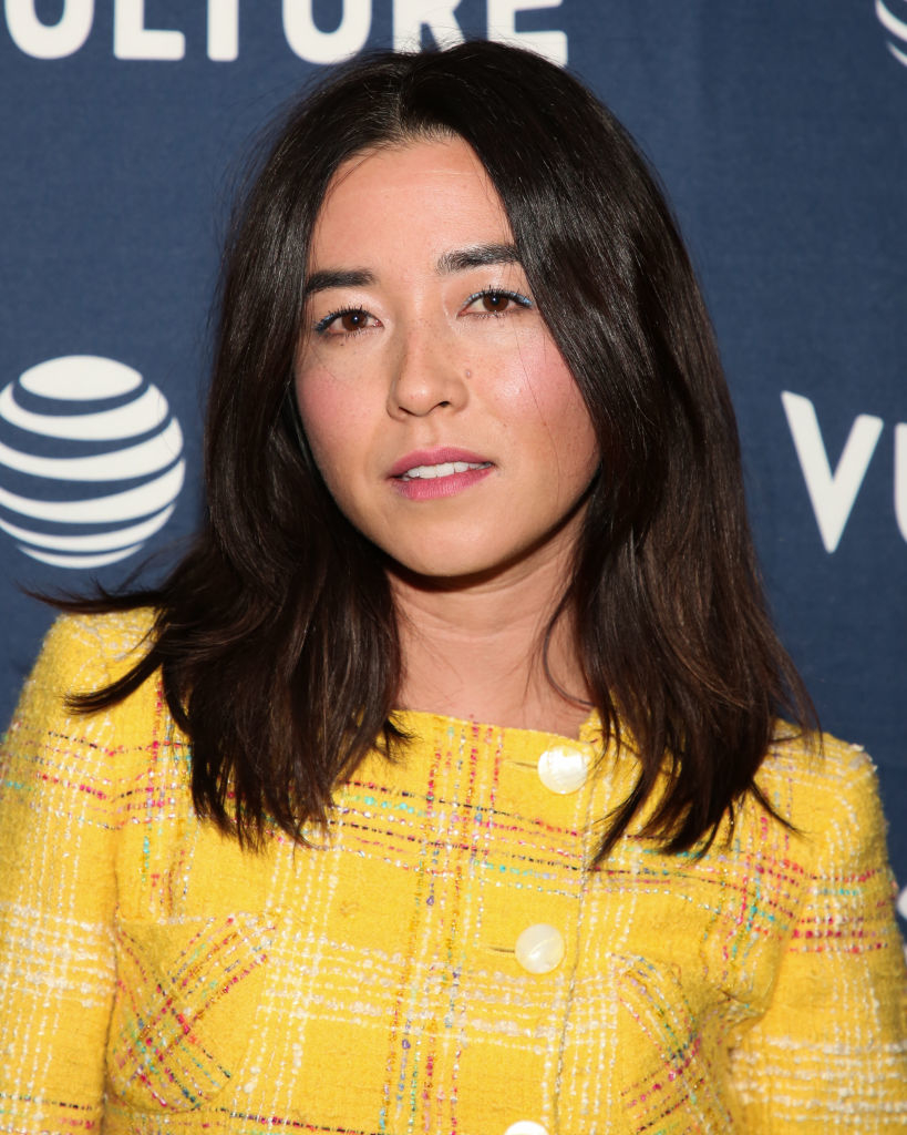 Maya Erskine poses in a patterned dress at an event