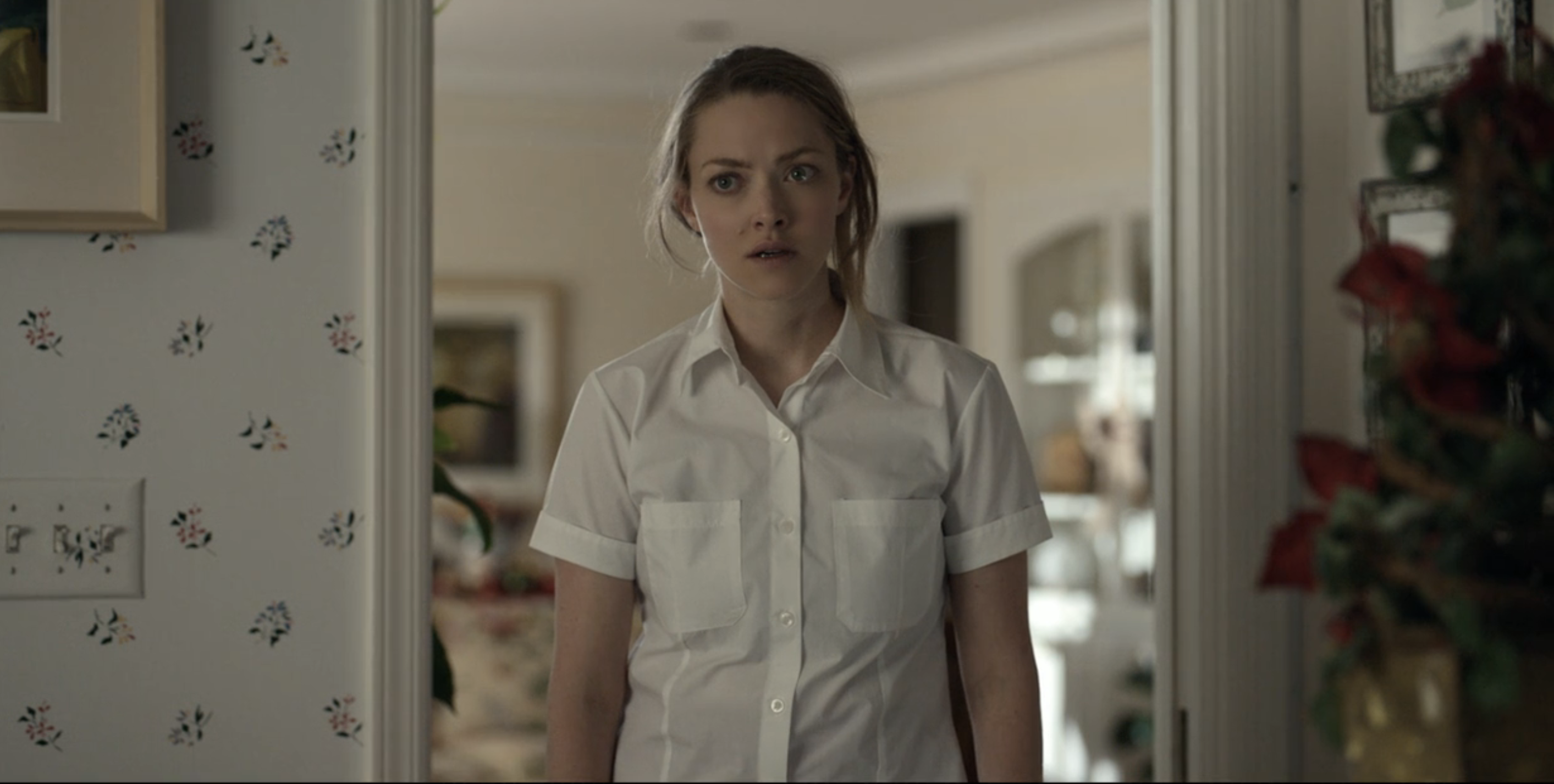 Elizabeth in a collared shirt looks surprised in a home setting