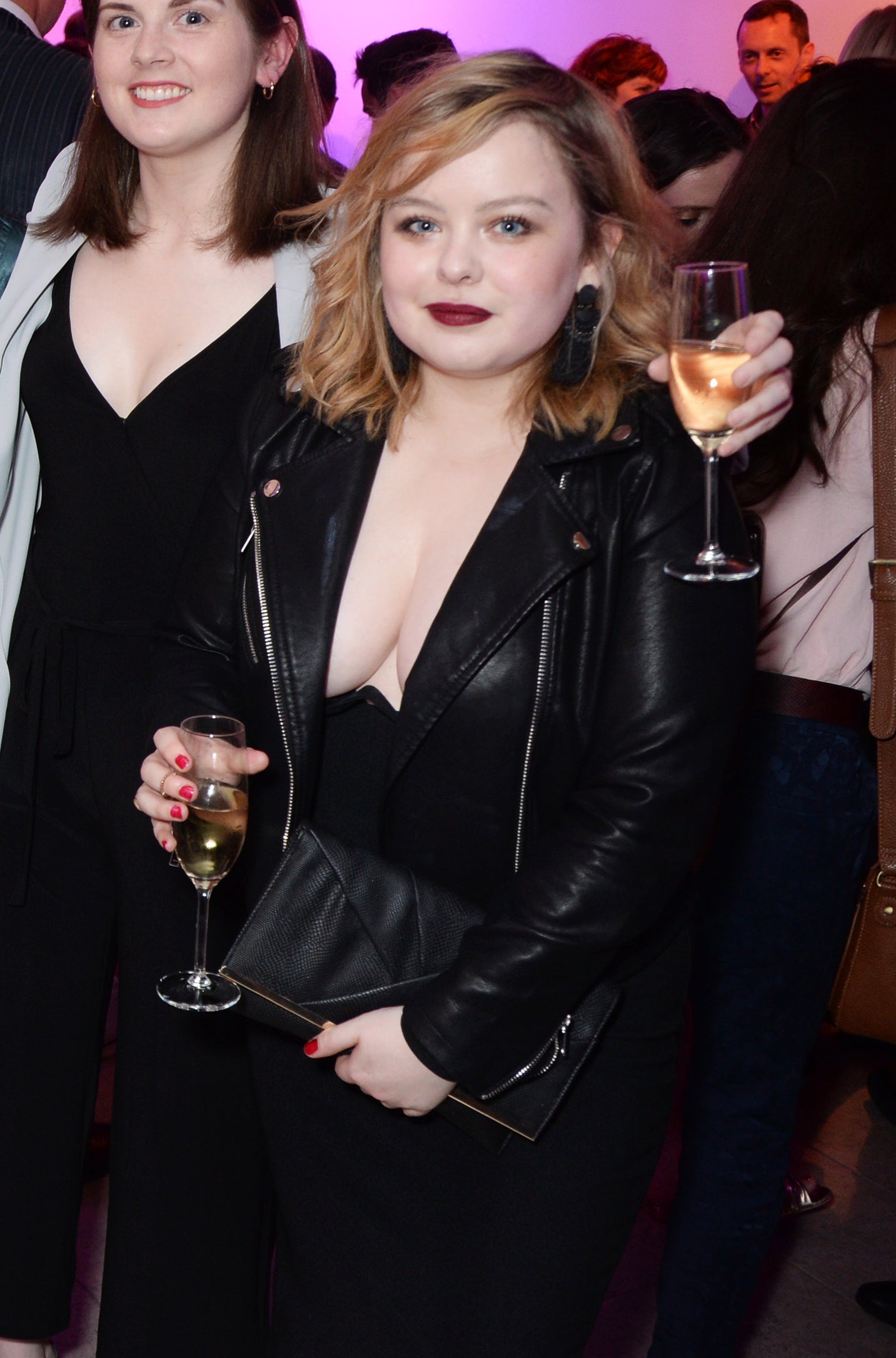Nicola in a leather jacket holding a drink