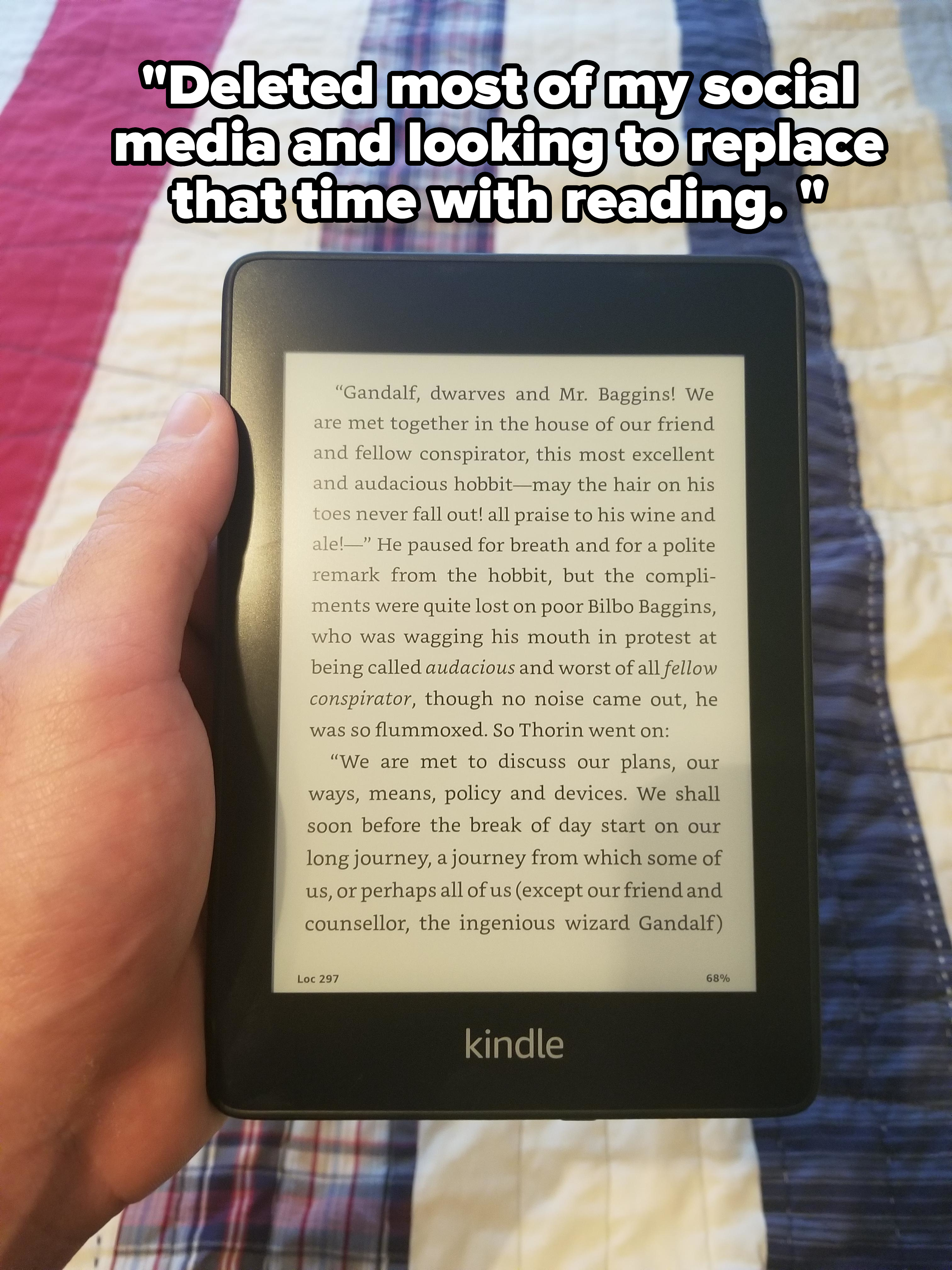 Hand holding a Kindle displaying a page from &quot;The Lord of the Rings&quot; with a text passage about Gandalf and Mr. Baggins