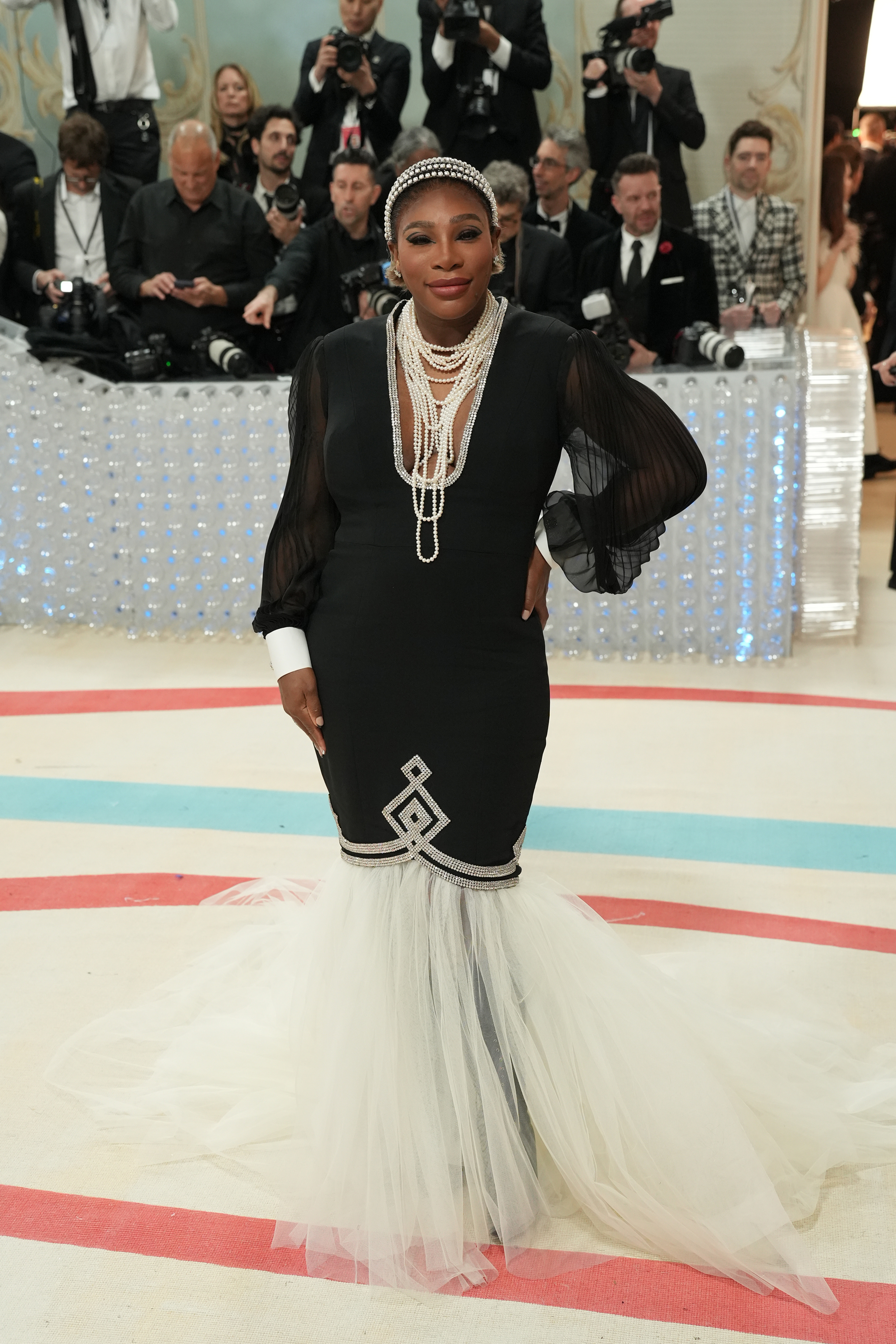 Serena Williams in a black dress with white accents and tulle at the bottom, wearing a silver necklace