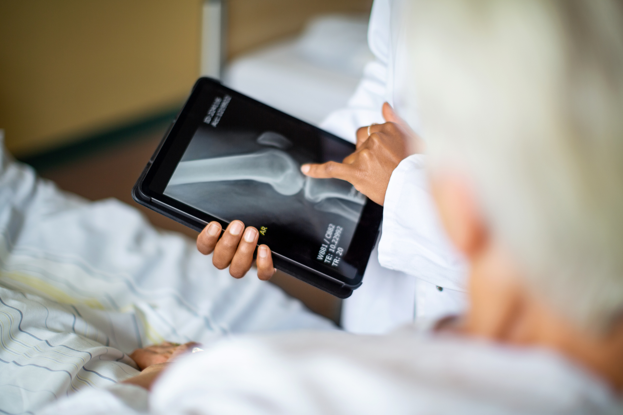 Doctor showing a patient an X-ray on a tablet