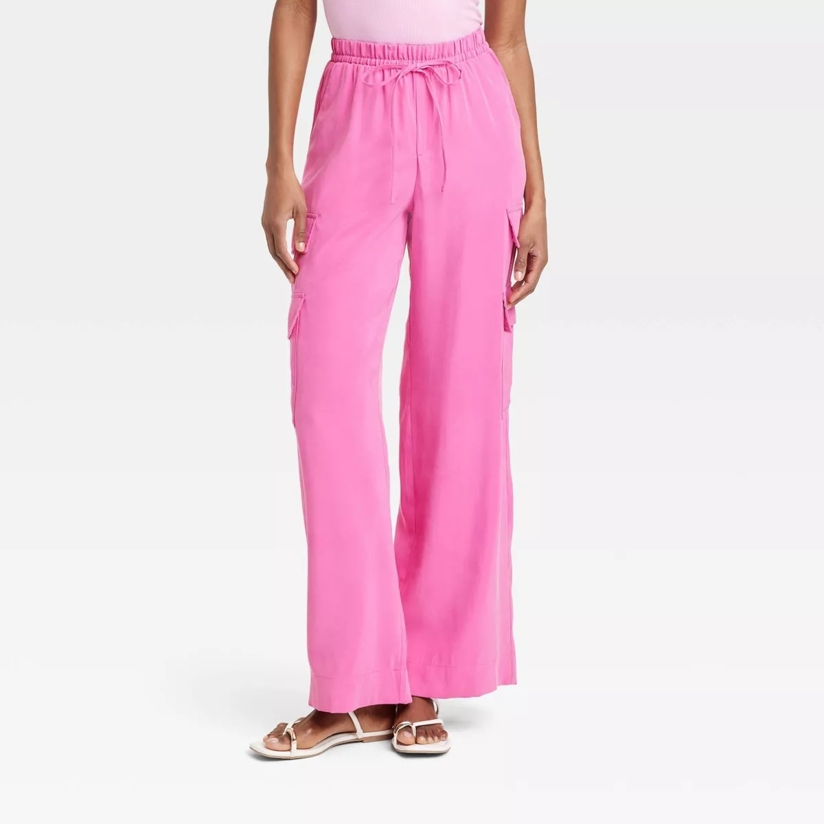 Person standing in pink cargo pants paired with simple sandals