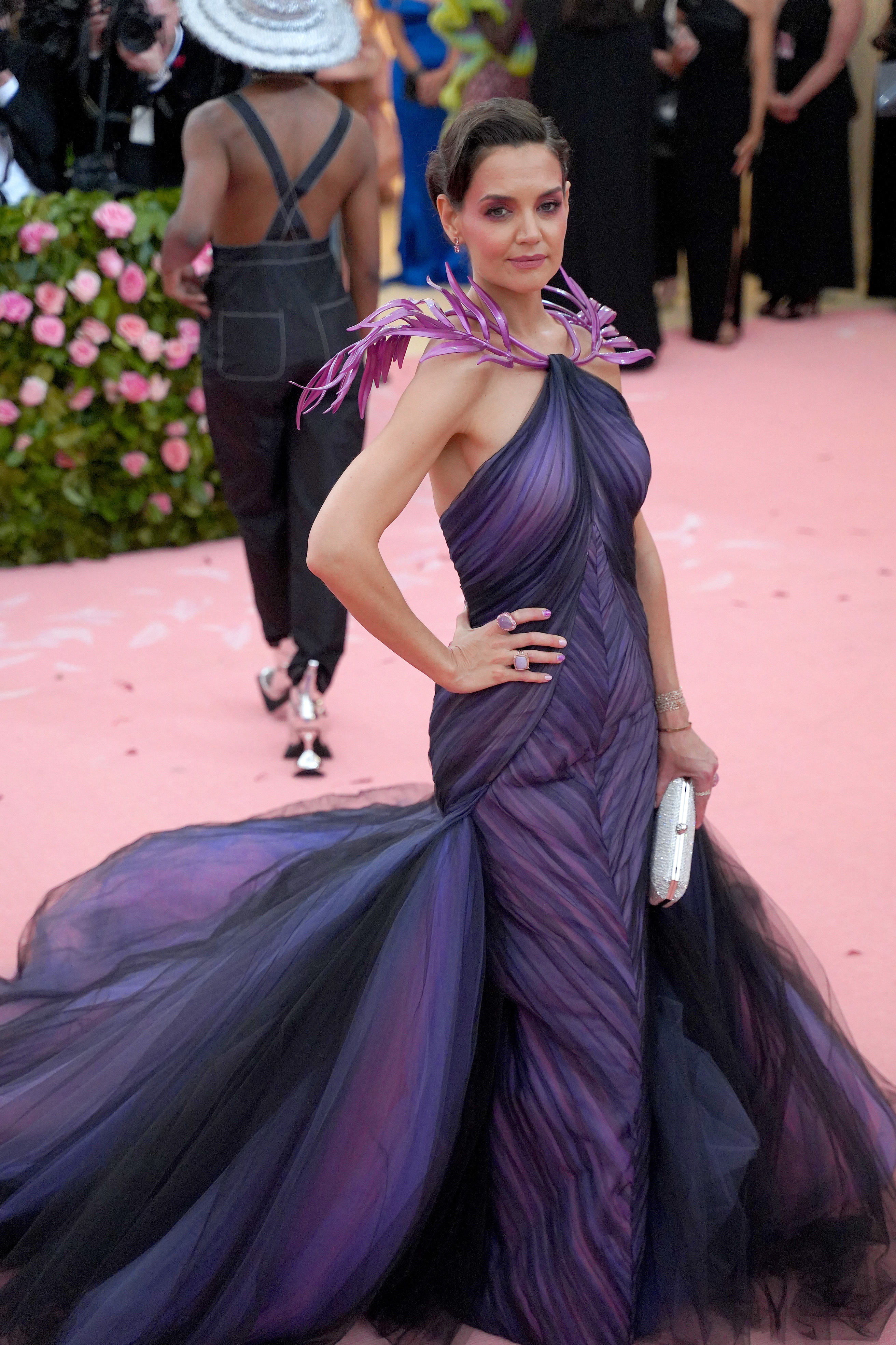 Woman in a purple gown with feather shoulder accents at a gala event