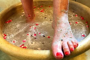 Model with feet in basin of water with Blue Haven Holistics foot scrub