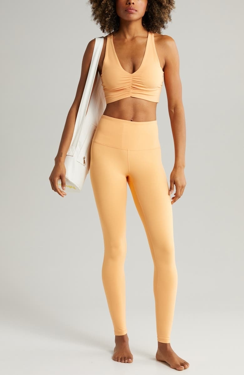 Model wearing high-rise orange workout leggings