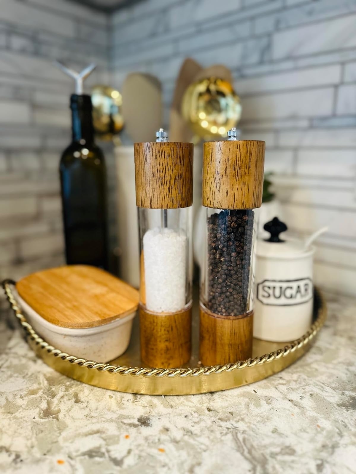 Salt and pepper grinders on a tray with kitchen accessories for a stylish table setting