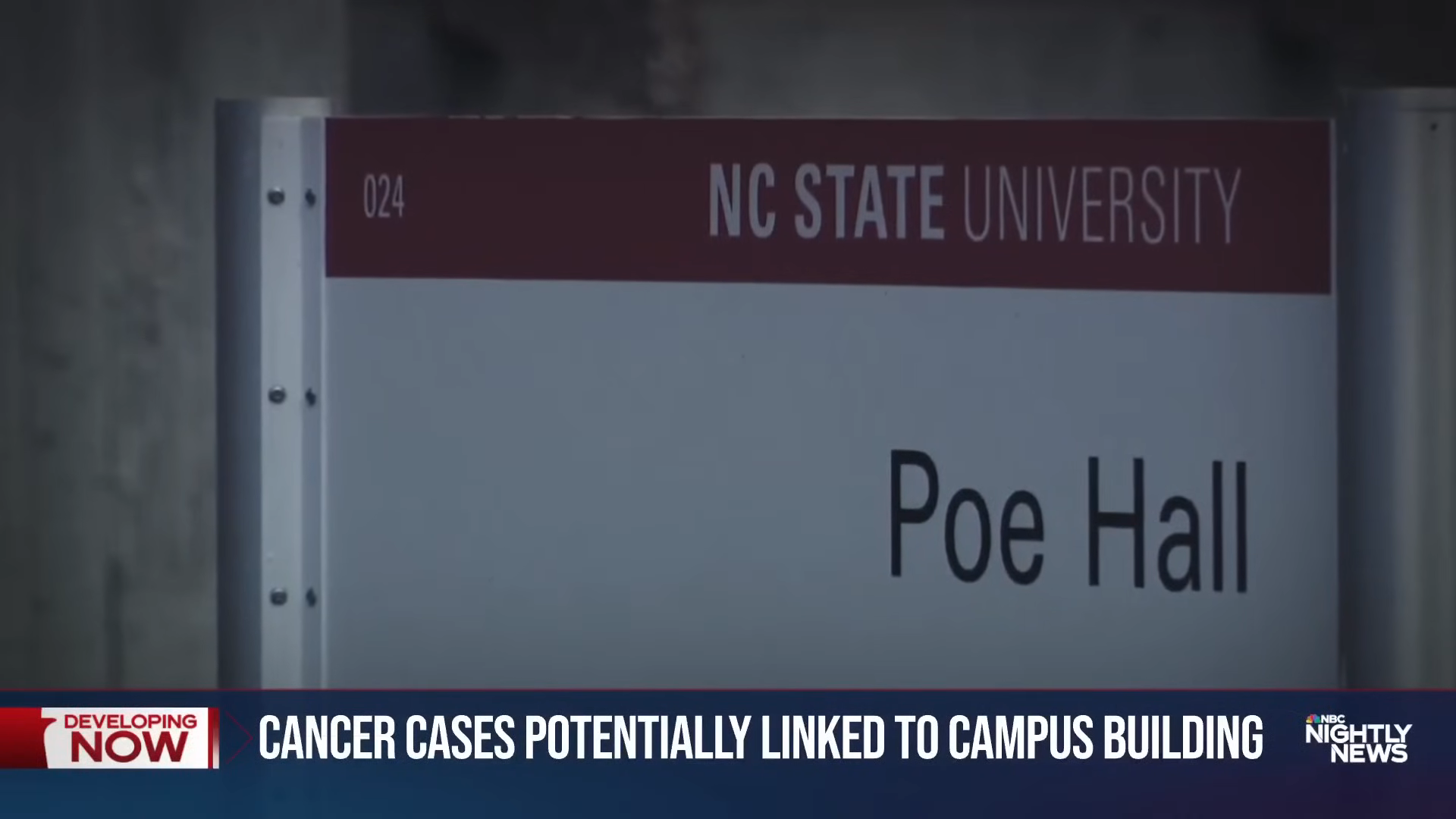 Sign reading &quot;Poe Hall&quot; at NC State University with a news banner about cancer cases possibly linked to a campus building