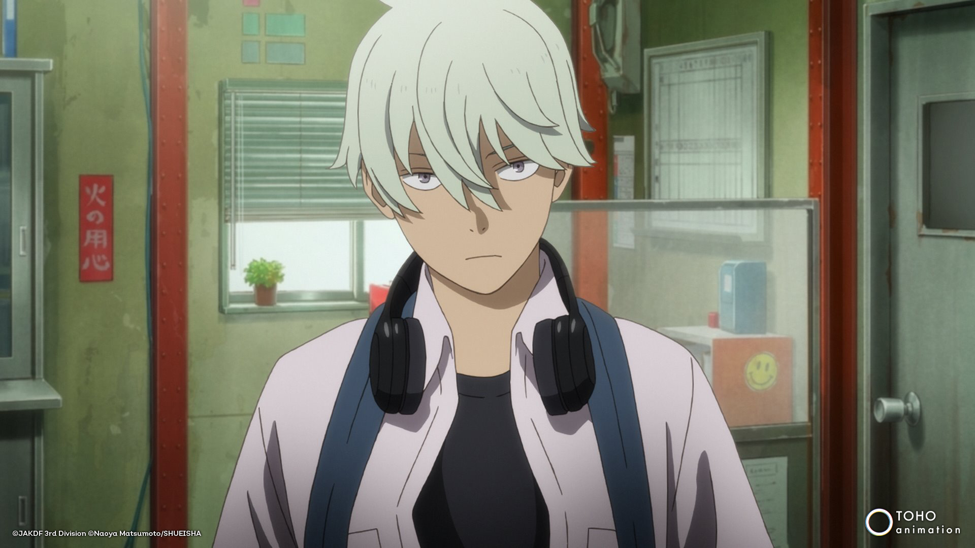 Personaje de anime masculino con auriculares alrededor del cuello y expresión seria