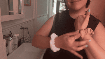 Person applying a bandage on their finger with first aid items in the background