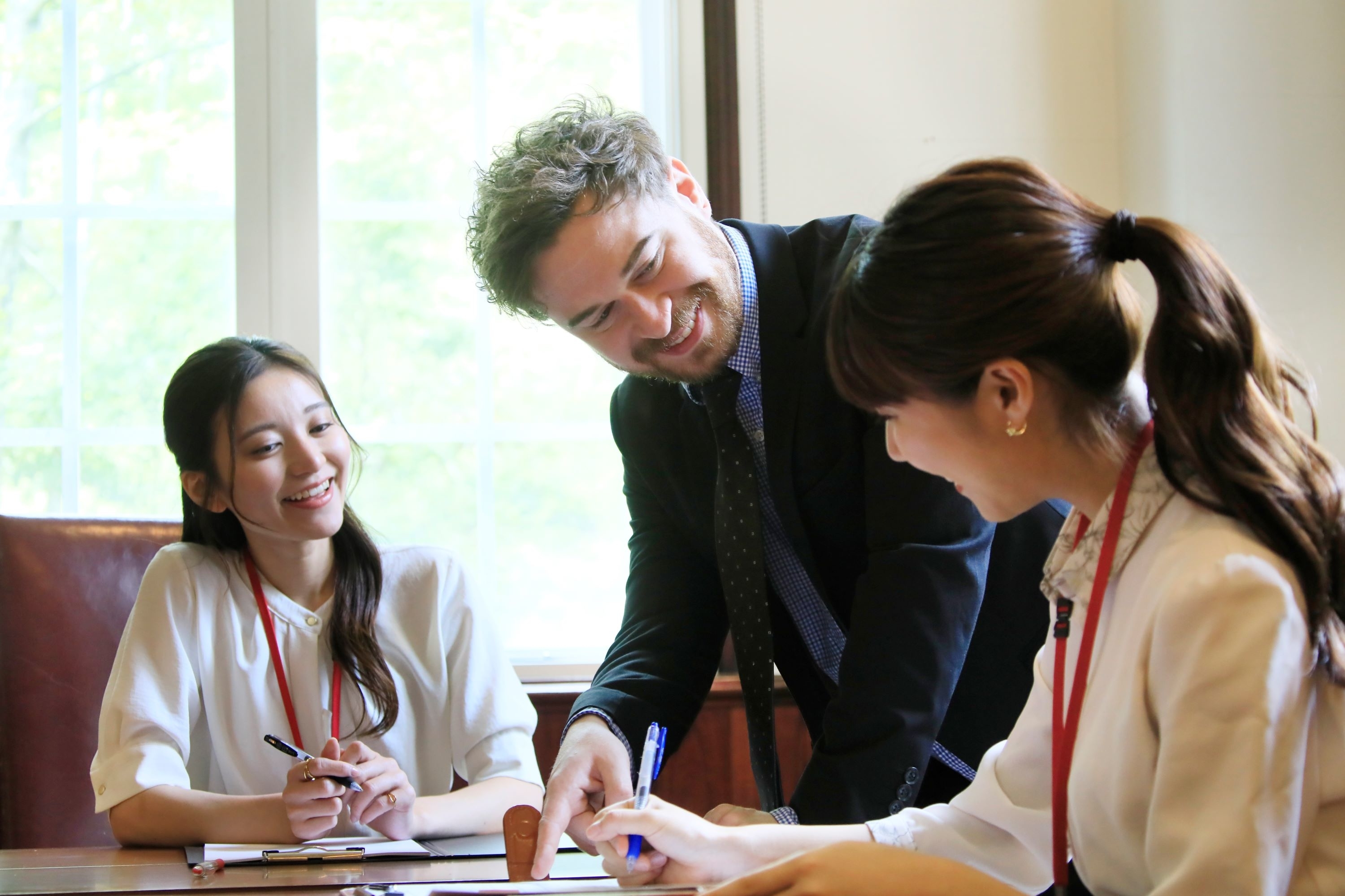 会議中、笑顔で書類に署名する人たち