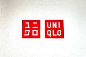 Two Uniqlo brand logos, one in Japanese and one in English, displayed on a wall