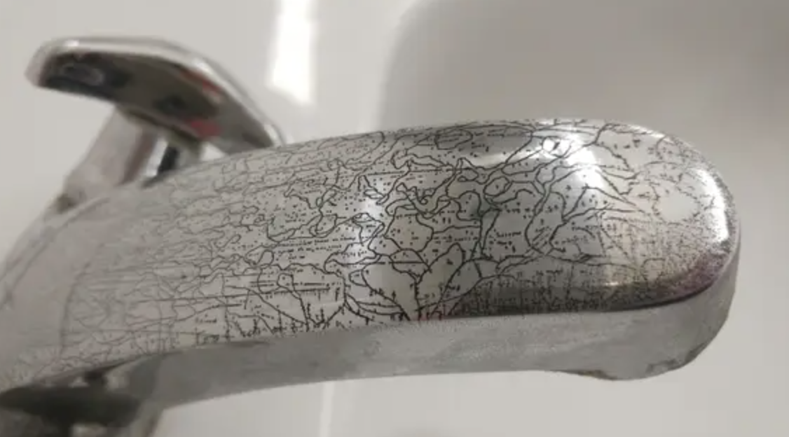 Close-up of a worn tap with a cracked surface, no identifiable persons