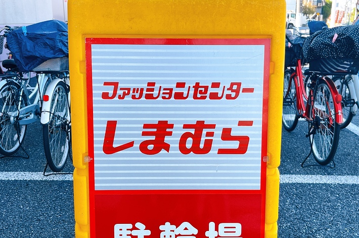 Signboard with Japanese text in front of bicycles, reads &lsquo;Furaringu Senta- Shimachari&rsquo; indicating a bike share spot