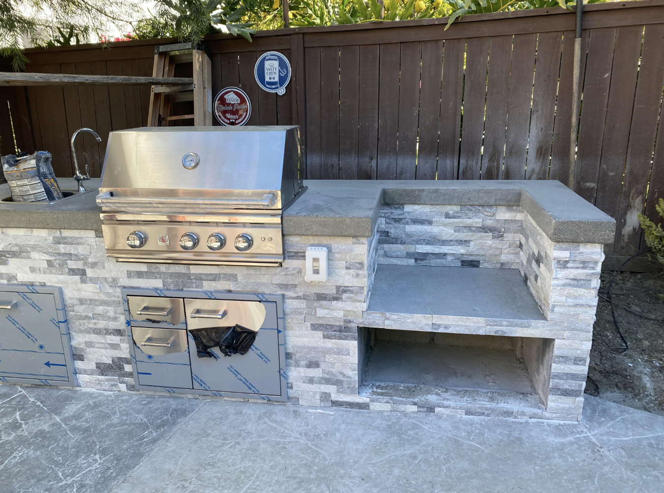 Backyard under construction with unfinished built-in BBQ island and concrete base
